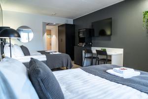a hotel room with two beds and a desk at Hotelli Sointu by UHANDA in Järvenpää