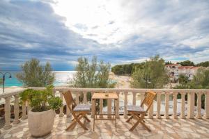 un balcone con due sedie e un tavolo e l'oceano di Rooms Plava Laguna a Primošten