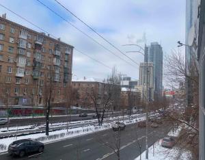 vistas a una calle de la ciudad con coches en la nieve en Arena Summit Apart Hotel en Kiev