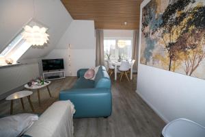 uma sala de estar com um sofá azul e uma mesa em Kleines Juwel in Brunsbüttel em Brunsbüttel