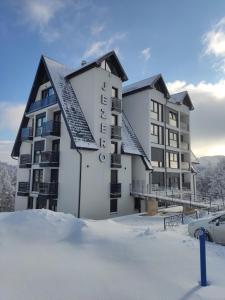 a building with snow in front of it at Apartmani Jezero Divčibare in Divčibare