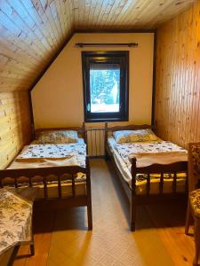 twee bedden in een kamer met een raam bij Ski kuća Boki in Jahorina