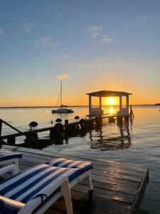 a sunset over the water with a dock and a boat at Hotel Aldea 19 Bacalar in Bacalar