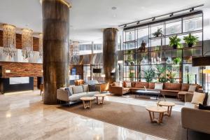 a lobby with couches and tables in a building at Melia Madrid Princesa in Madrid