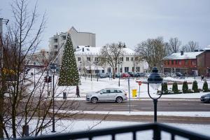 a christmas tree in a parking lot with a car at Center apartment in Plungė