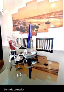 ein Glastisch mit zwei Weingläsern darüber in der Unterkunft Villa Ágatha, vacaciones en familia en Lanzarote in Playa Blanca