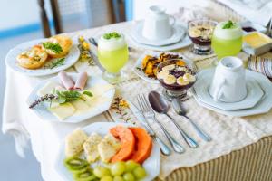 een tafel met borden met eten en drinken erop bij Aqualtune Pousada in Barra Grande