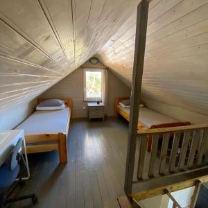 een zolderkamer met 2 bedden en een trap bij Camping Zaki House No 6 in Jūrkalne