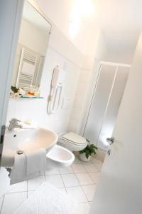 a white bathroom with a toilet and a sink at Hotel Garden in Levanto