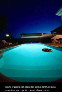 ein großer blauer Pool in der Nacht mit einem Gebäude in der Unterkunft Villa Ágatha, vacaciones en familia en Lanzarote in Playa Blanca