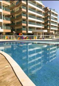 a large swimming pool in front of a building at Apto paraíso praia dos anjos in Arraial do Cabo