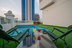 two glasses of wine sitting on a table on a balcony at Vista City Hotel in Dubai