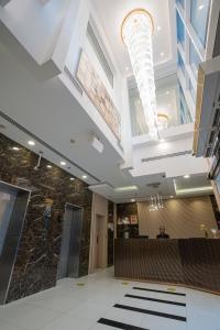 Vista City Hotel في دبي: لوبي فندق فيه رجل يجلس في مكتب