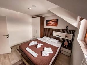 a bedroom with a bed with towels on it at Apartmani Džanković in Kopaonik +86 photos