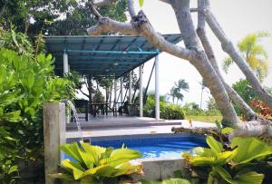 a house with a swimming pool and a tree at Hasina Resort @Sedili in Kota Tinggi