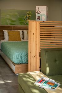 a bedroom with a bed and a green chair at Olive Lemon Biophilic House & Lush Forest Garden in Vamos