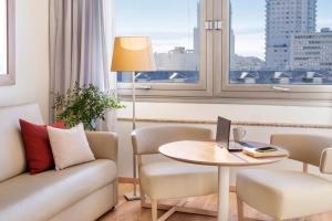a living room filled with furniture and a window at Melia Madrid Princesa in Madrid