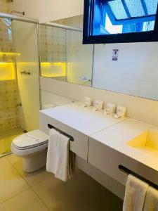 uma casa de banho com um lavatório, um WC e um espelho. em Hotel Lenheiros em São João del Rei