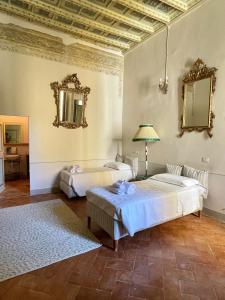 two beds in a room with two mirrors at Palazzo Lauri Spoleto in Spoleto