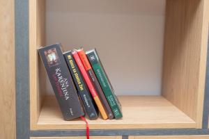 a row of books sitting on a shelf at Modern Mountain Apartman 202 in Kolašin