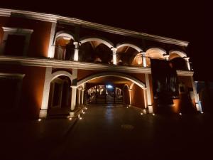 an empty building with an archway at night at Hotel Real de los Alamos in Álamos