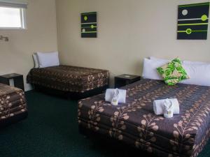 Łóżko lub łóżka w pokoju w obiekcie Palm Motel Waihi