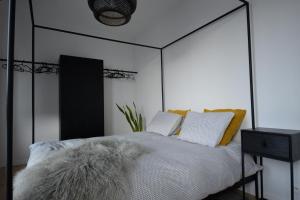 a bedroom with a black and white bed with a furry pillow at The Penthouse, oasis of light and inspiration in Antwerp
