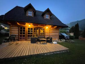 eine Hütte mit einer Terrasse mit einem Tisch und Stühlen in der Unterkunft Nasa Chata in Levoča