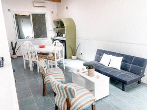 a living room with a couch and a table and chairs at Casa en el Bosque con piscina in Ciudad Lujan de Cuyo