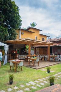 a patio with tables and chairs in a yard at Manaca Hospedaria in Ilhabela