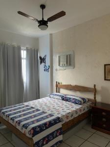 una camera con letto e ventilatore a soffitto di Apartamento Pé na Areia e águas tranquilas no centro de Guarapari a Guarapari