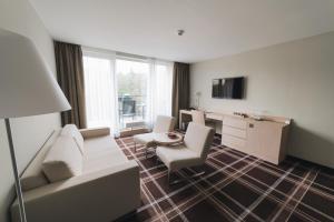 a living room with a couch and chairs and a table at Hotel Split in Kadaň
