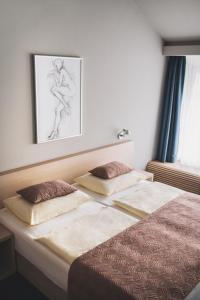 a bedroom with two beds and a picture on the wall at Hotel Split in Kadaň