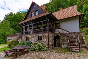Casa de piedra con escalera y mesa de picnic en Villa Szalamandra - az Erdőszéle en Matraalmas