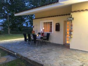 a patio with a table and chairs next to a house at Villa Anastasia! in STROFYLIA pine FOREST!!! in Kamenitsotaíika