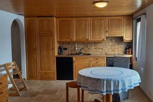 a kitchen with wooden cabinets and a table in it at Känzeli - Ferienwohnung mit Traumaussicht in Beatenberg