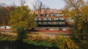 a building with cars parked in front of a river at Wellness Hotel Split in Kadaň