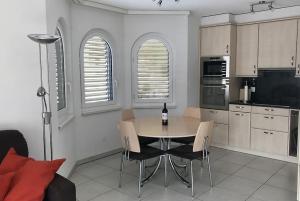 eine Küche mit einem Tisch mit Stühlen und einer Flasche Wein in der Unterkunft Residenz Ambassador A11 in Leukerbad
