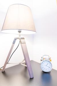 a lamp and an alarm clock sitting next to a clock at Modern Apartment in Salford Manchester UK in Manchester