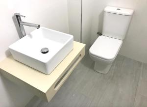 ペニスコラにあるTARONGERS 6の白い洗面台とトイレのあるバスルーム +4枚の写真