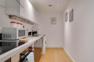 eine Küche mit weißen Geräten und einer Arbeitsplatte in der Unterkunft Arcadian City Centre Apartments with Balcony in Birmingham