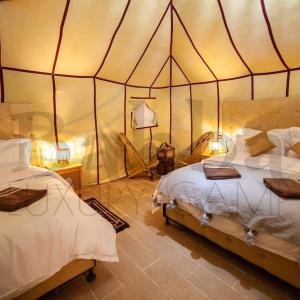 AdrouineにあるSunset luxury campのテント内のベッドルーム1室(ベッド2台付)