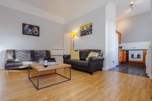 a living room with a couch and a table at Linlithgow Apartment in Linlithgow