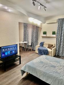 a living room with a bed and a tv in it at Apartment near Zybitskaya in Minsk