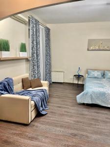salon z kanapą i łóżkiem w obiekcie Apartment near Zybitskaya w Mińsku