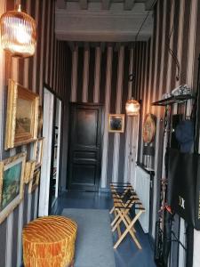 un corridoio con pareti a strisce, porta e sedie di "la suite" a Talant