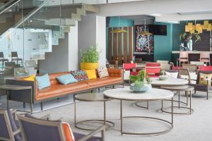 a lobby with a couch and tables and chairs at Metria Hotel in León