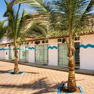 two palm trees in front of a building at Nauti-k Beach Hotel in Tumbes
