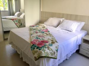 una camera da letto con un letto con una coperta floreale sopra di Casa Estrela do Mar Guarajuba a Guarajuba Altre 51 foto