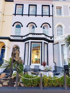 a white building with a fence in front of it at The Patricia in Torquay